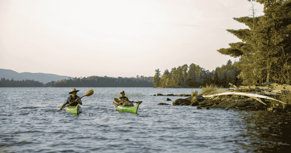 ken whiting and tour guide kayaking in les Laurentides, Québec while the sun is setting paddle tales paddletv facing waves