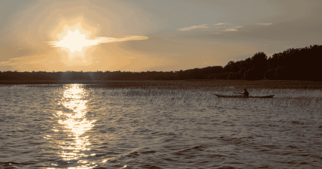 sunset over the water while ken whiting kayaks in quebec authentique