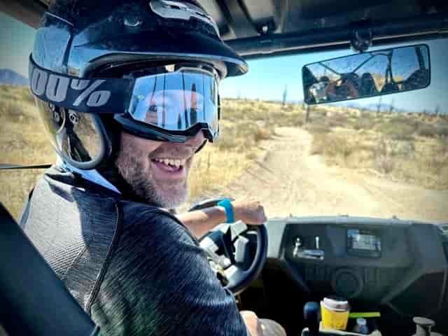 Jonathan Thompson, smiling at the camera from the drivers seat of an ATV on a trail, Scottsdale, Arizona