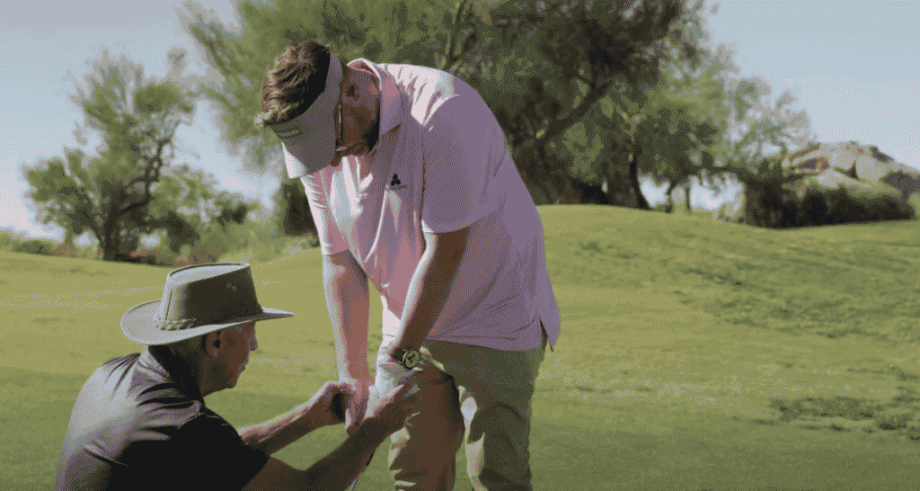 Jonathan Thompson, is having his grip adjusted by a pro on the golf green, Scottsdale, Arizona